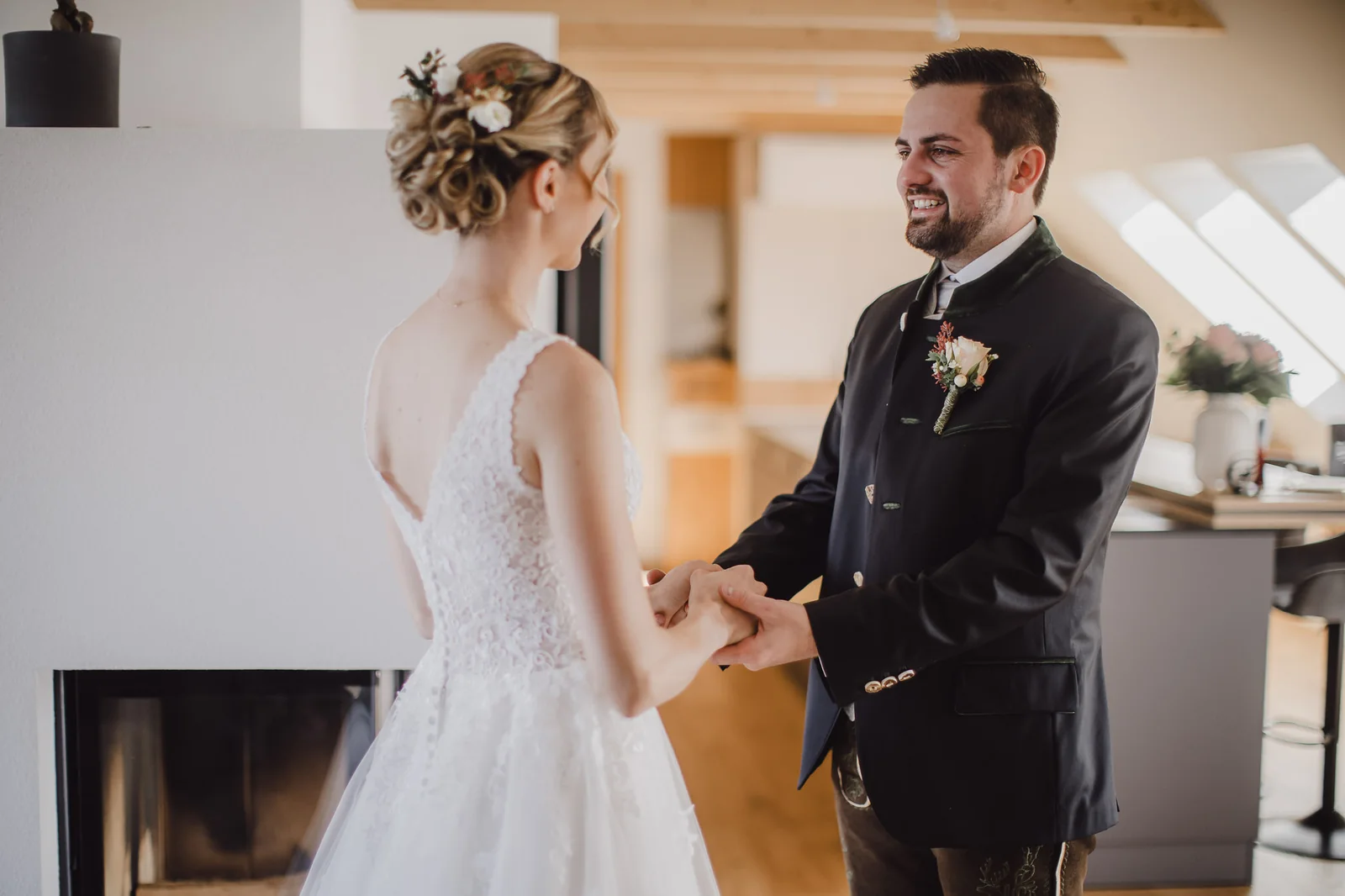 Braut und Bräutigam halten sich beim First Look an den Händen und lachen einander an