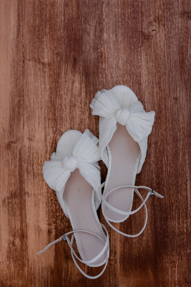 Weiße Brautschuhe auf Holz beim Getting Ready zur Trachtenhochzeit am Traunsee