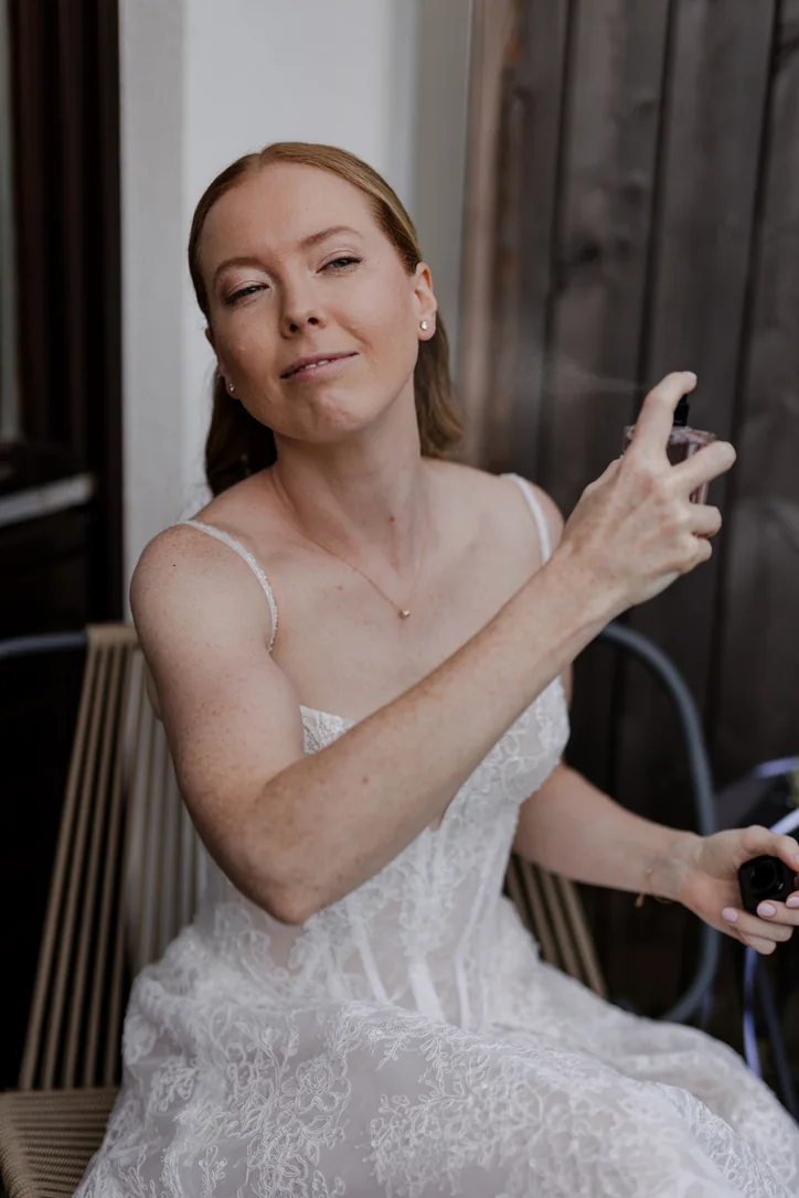 Braut beim Getting Ready im hellen Spitzenkleid vor der Hochzeit am Traunsee