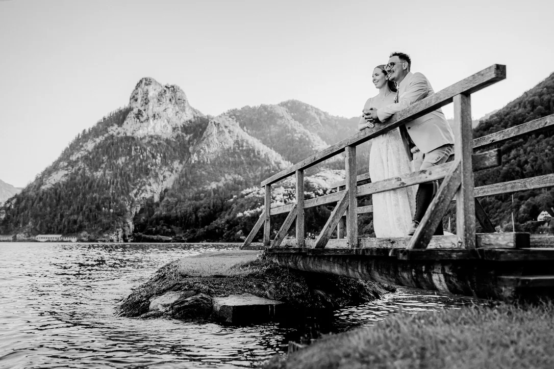 Schwarzweißes Brautpaar auf einem Holzsteg über dem Traunsee im Salzkammergut