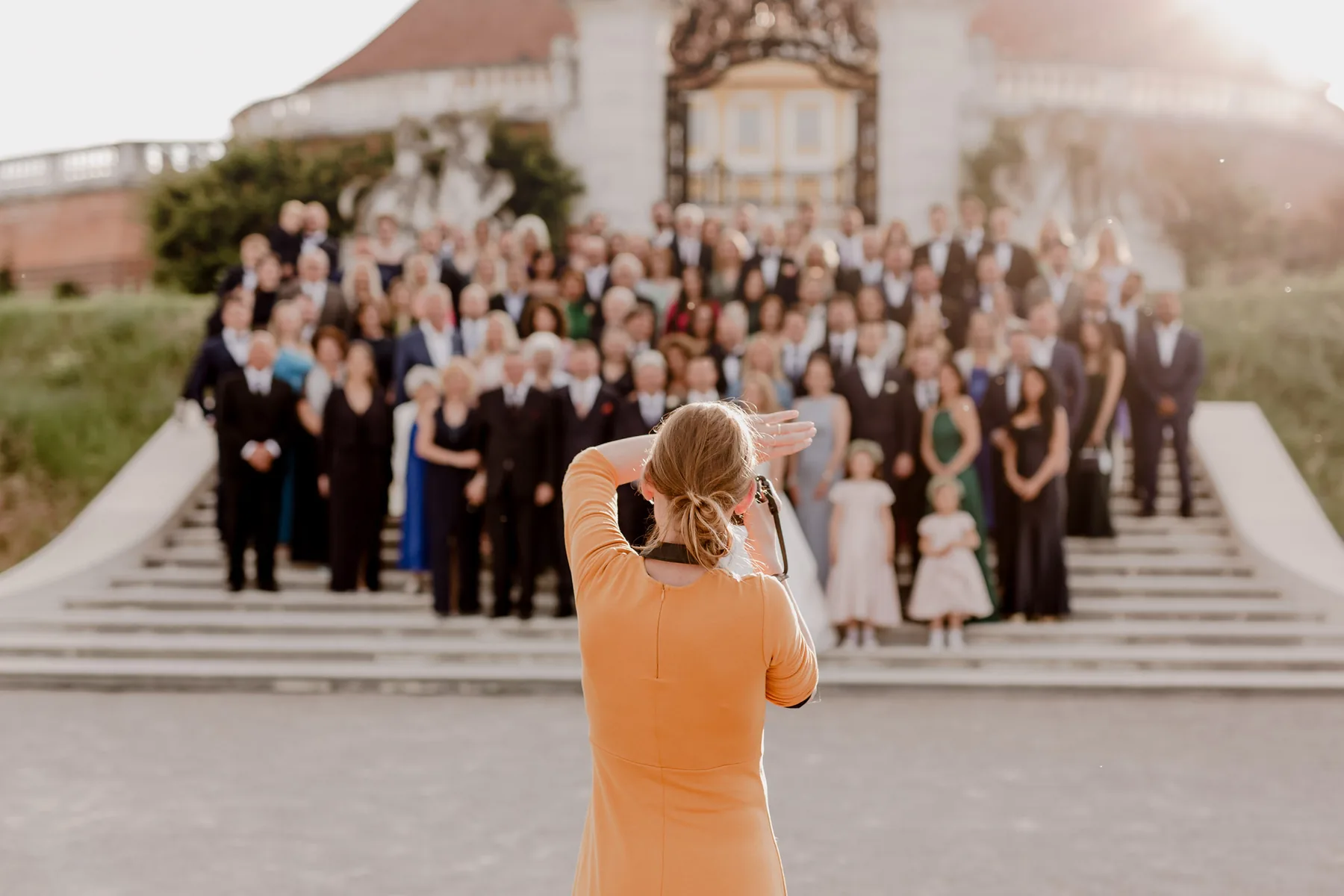 Miriam fotografiert eine große Hochzeitsgesellschaft auf den Stufen vor einem Schloss