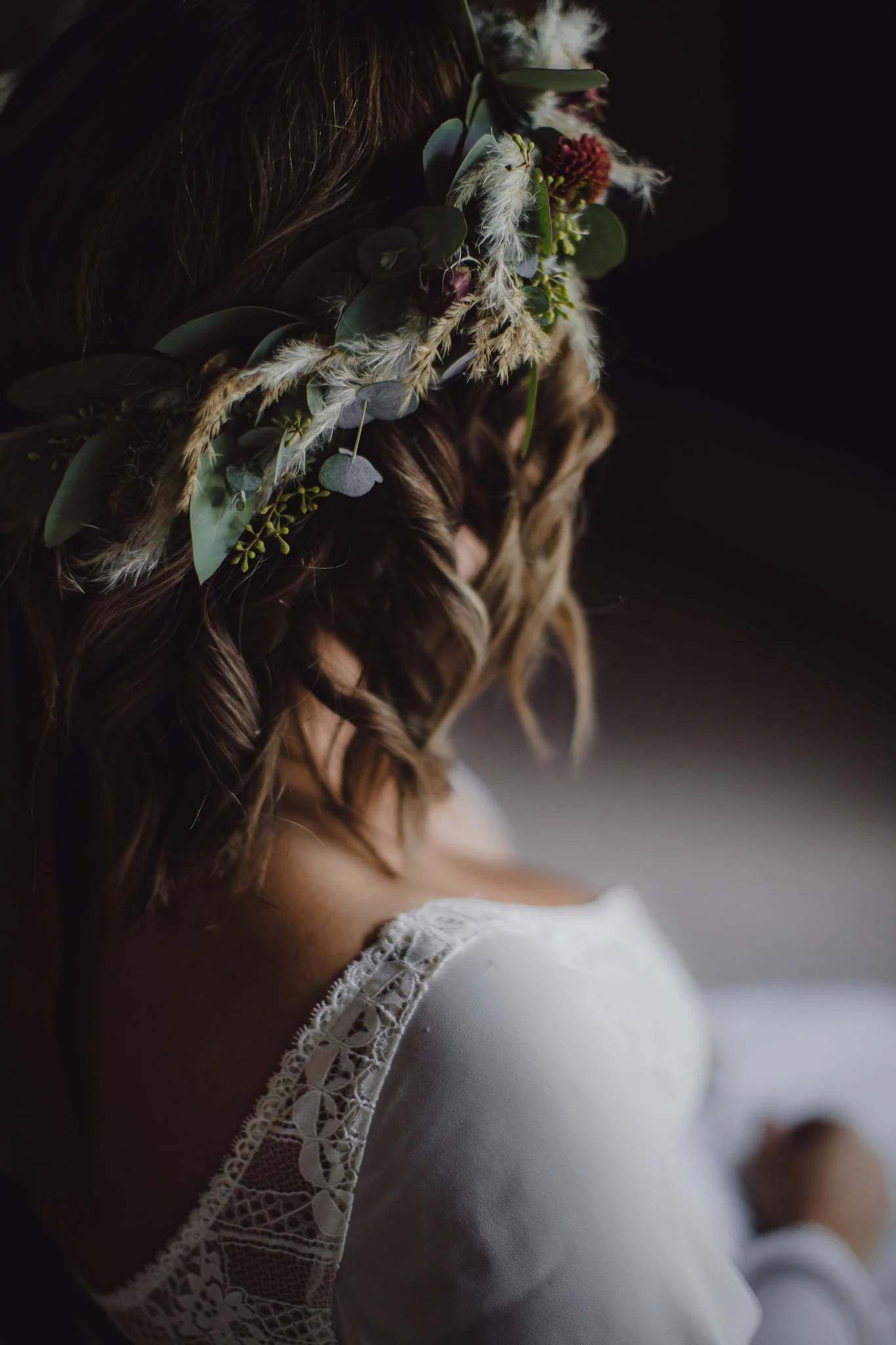 Braut von hinten mit locker gesteckter Hochzeitsfrisur, Blumenkranz und Spitzenkleid
